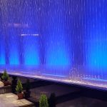 Detalle de la cortina de agua iluminada en el interior de un centro comercial