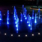 Crystal-clear jets of water illuminated in a fountain , interactive fountain
